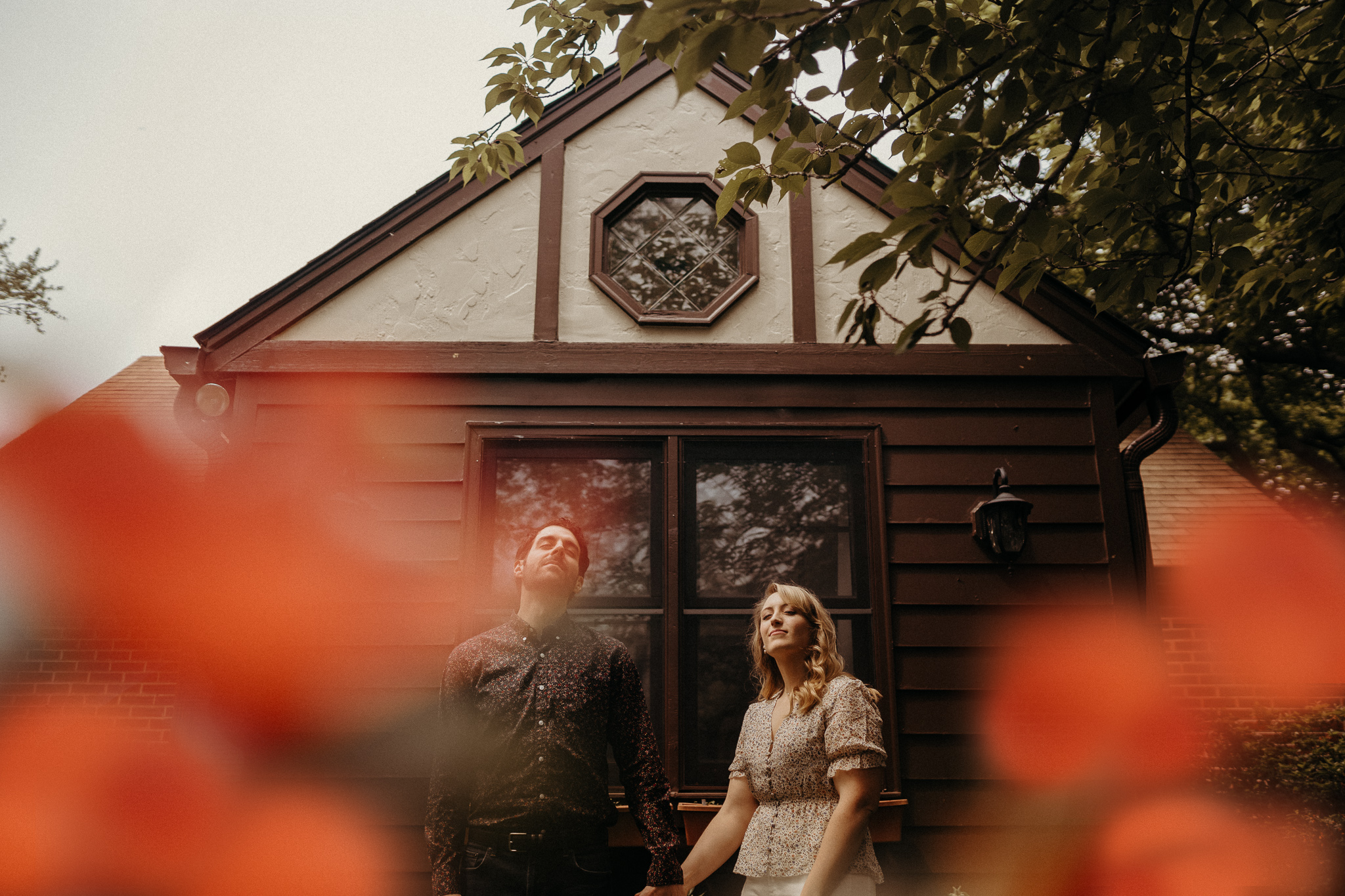 Chill in-home engagement session idea with homemade cake, two cats, a dog, and a beautiful backyard of blooming azaleas